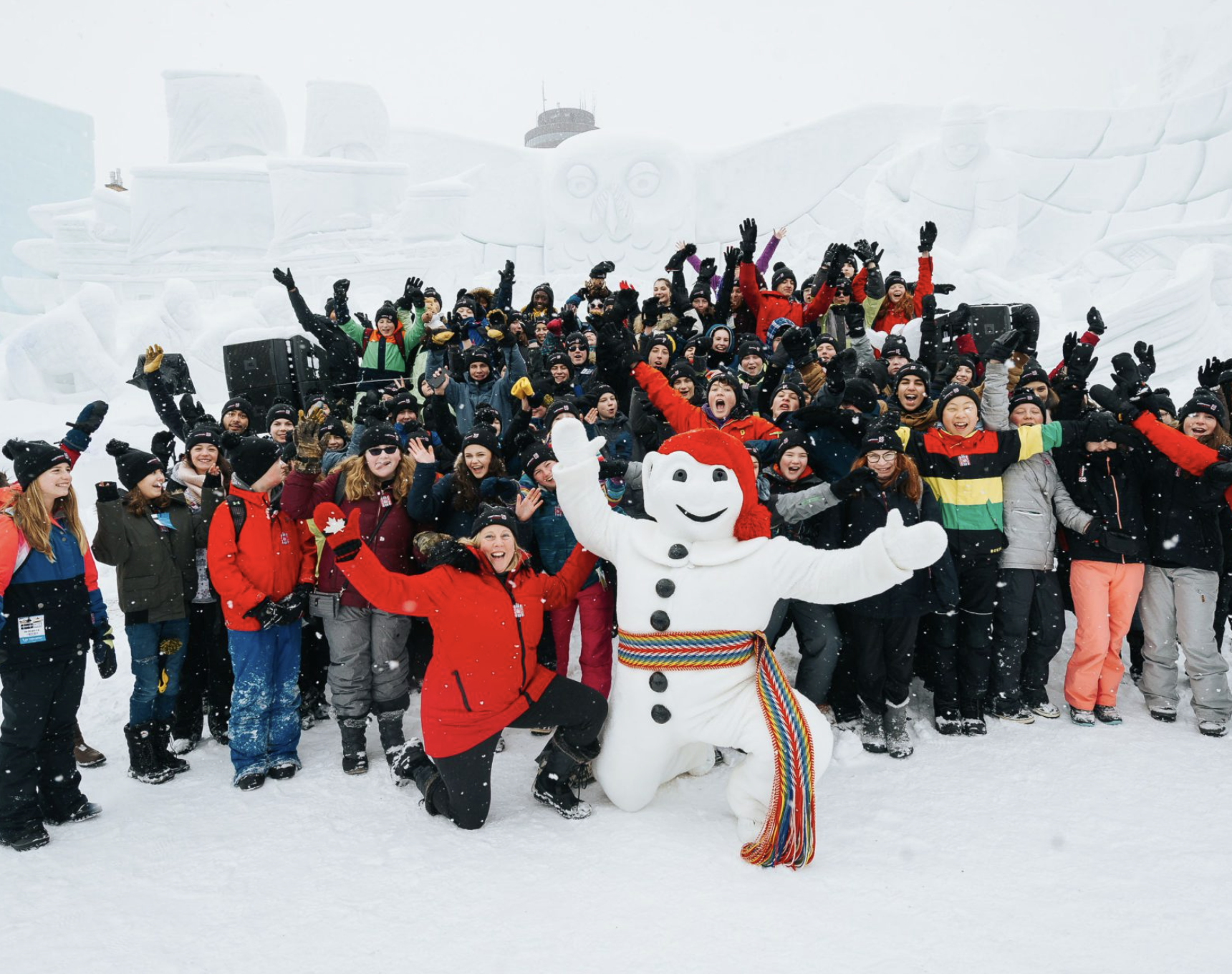 A large group of youth and chaperones gather with Bonhomme at the Quebec Winter Carnival.